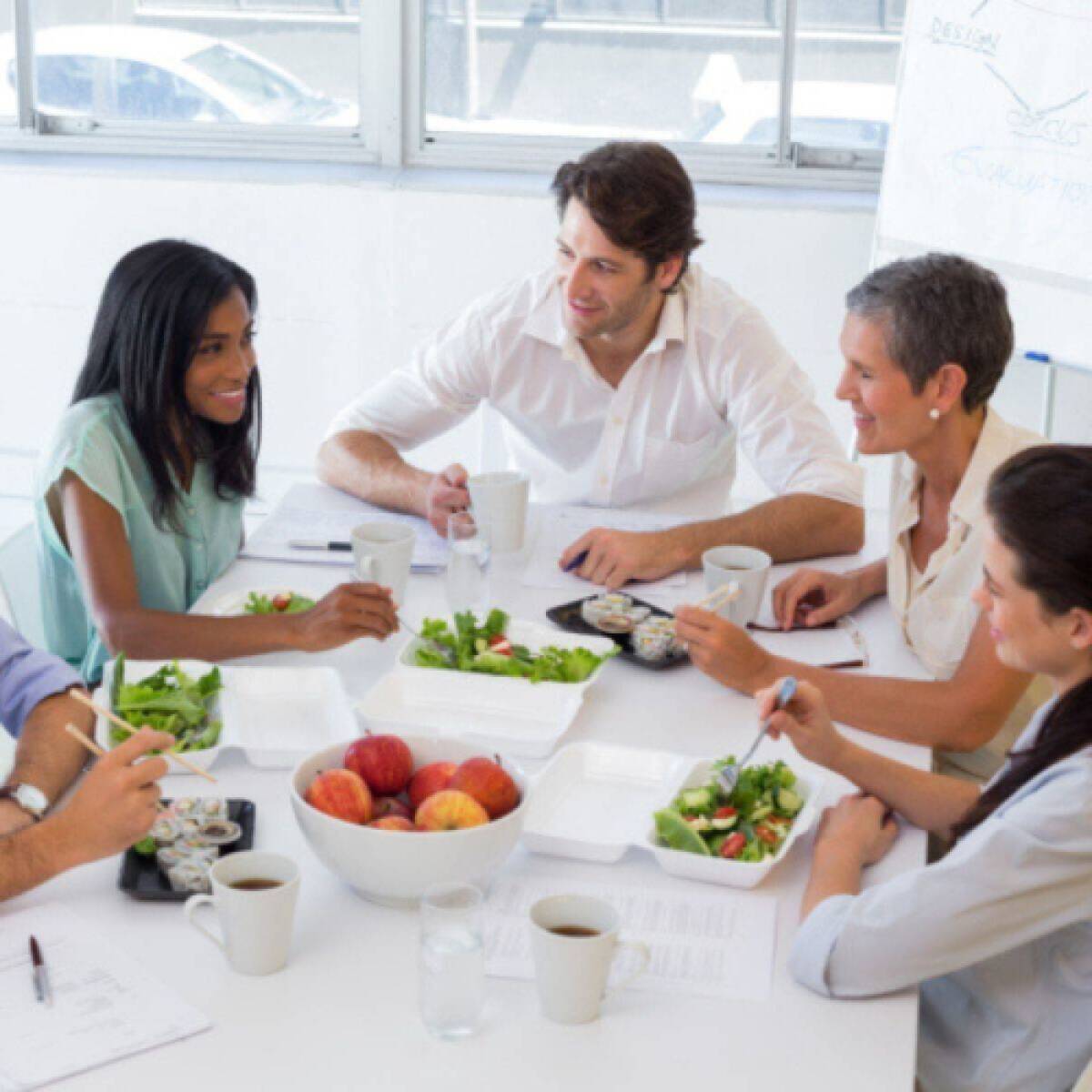 A group of adults working around a table filled with healthy foods